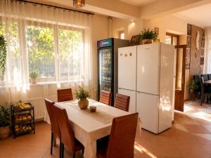 a kitchen with a table and a white refrigerator at Vila George in Eforie Sud