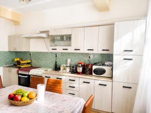a kitchen with a table with a bowl of fruit on it at Vila George in Eforie Sud