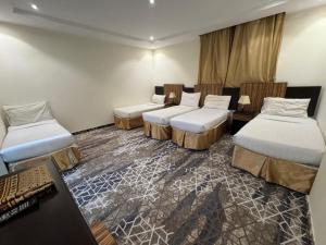a hotel room with three beds and a desk at فندق اسرار التيسير in Mecca