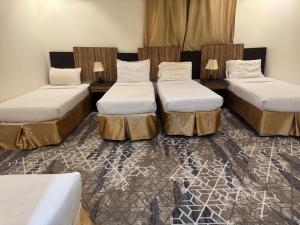a room with three beds and two lamps at فندق اسرار التيسير in Mecca