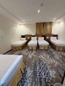 a room with four beds in a room at فندق اسرار التيسير in Mecca