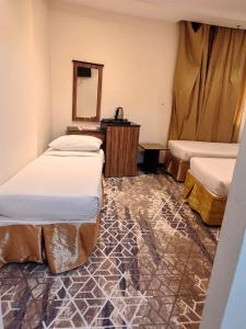 a room with two beds and a mirror at فندق اسرار التيسير in Mecca