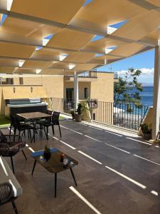 a patio with tables and a piano on top of a building at B&B Kairos Itala in Itala