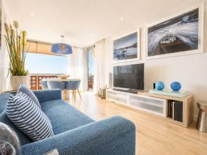 a living room with a blue couch and a television at RenTenerife Elim Ocean in La Tejita