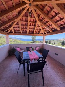 a table and chairs on a balcony with a wooden ceiling at Villa Fragola in Doli