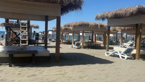 a beach with chairs and umbrellas on the beach at Sabo Villa in Pečurice