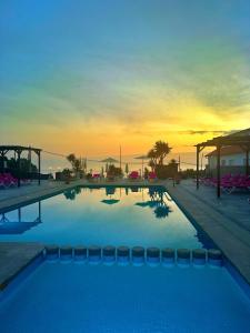 Ein Swimmingpool mit Sonnenuntergang im Hintergrund in der Unterkunft Hotel Marola in A Lanzada