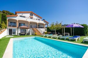 a villa with a swimming pool and a house at Villa Panoramic in Santa Susanna