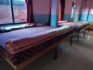 two beds in a room with a window at Hotel Devi's Fall View in Pokhara