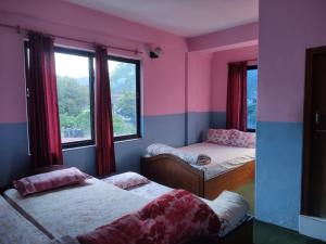 a room with two beds and a window at Hotel Devi's Fall View in Pokhara