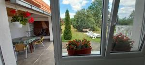 a window with a view of a patio with flowers at Apartmani Ćosić in Kuršumlija +65 photos