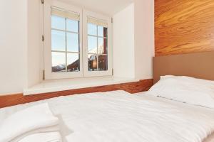a bedroom with a white bed and a window at Berghaus Stuben Arlberg mit Sauna Panoramablick und Nähe zur Piste in Stuben am Arlberg