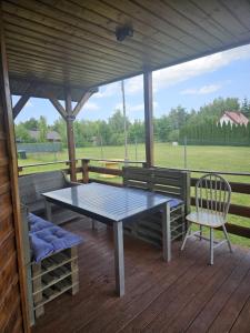 a table and two chairs on a wooden deck at Domek skandynawski in Łuszczewo