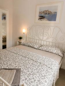 a white bed in a bedroom with a picture on the wall at Apartments Merlin in Novigrad Istria