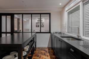 a kitchen with a black counter top and a sink at Estúdio 196 in Bento Gonçalves