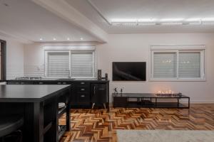 a living room with a table and a tv at Estúdio 196 in Bento Gonçalves
