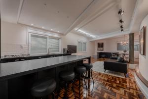 a kitchen and living room with a bar with stools at Estúdio 196 in Bento Gonçalves