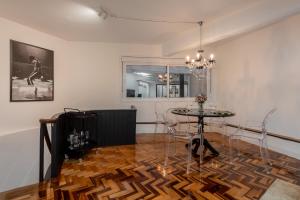 a dining room with a table and a chandelier at Estúdio 196 in Bento Gonçalves +8 photos