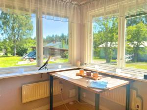 a room with a table in front of two windows at Hus Indalsälven in Hammarstrand
