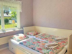 a bed with two pillows on it next to a window at Hus Indalsälven in Hammarstrand