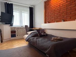 sypialnia z łóżkiem i ceglaną ścianą w obiekcie BaSoTo w mieście Sopot