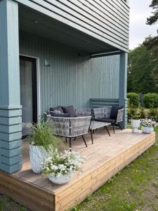 a deck with two chairs and a couch on a house at Liiva apartement Kärdla in Kärdla