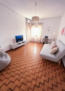 a living room with a white couch and a wooden floor at Casa Lupoli in Caserta