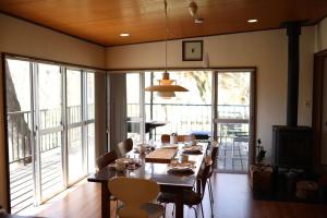 a dining room with a table and chairs and a large window at 木漏れ日の森で都会では味わえない静寂を那須の自然を満喫する貸別荘つつじ山 in Nasu