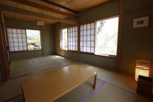 a room with a table in a room with windows at 木漏れ日の森で都会では味わえない静寂を那須の自然を満喫する貸別荘つつじ山 in Nasu