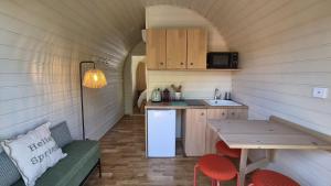 a small kitchen in a tiny house with a table at Les Lodges de la Moivre in Saint-Jean-sur-Moivre