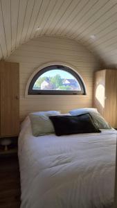 a bedroom with a large bed with a window at Les Lodges de la Moivre in Saint-Jean-sur-Moivre