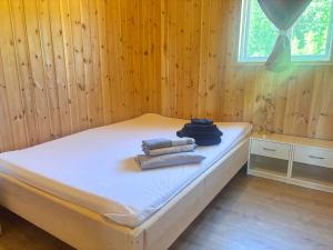 a bed in a wooden room with towels on it at Sodra Fullsjön in Stugun