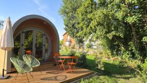 a deck with chairs and a table and an umbrella at Les Lodges de la Moivre in Saint-Jean-sur-Moivre