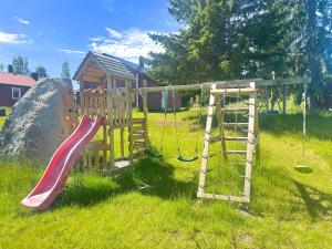 a playground with a slide and a swing at Sodra Fullsjön in Stugun