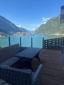 a table and chairs on a deck with a view of a lake at Basement apartment in Tokheim