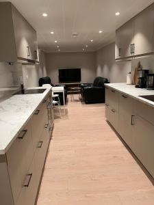 a kitchen with white counter tops and a living room at Basement apartment in Tokheim