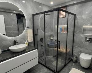 a bathroom with a glass shower and a sink at Luxury apartment With 3 Ac and Free Parking in Lahore