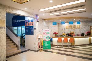 a lobby of a hotel with orange chairs and a counter at Guangzhou Xin Yue Xin Hotel in Guangzhou