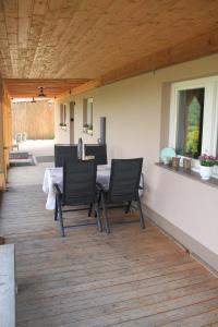 a patio with a table and chairs on a deck at Ferienwohnung Moin Eifel in Schleiden