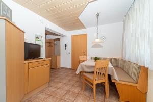 a living room with a dining table and a television at Haus Muntschnei in Sankt Gallenkirch