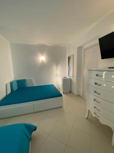 a bedroom with a blue bed and a dresser at Amore di Mare in Cagliari