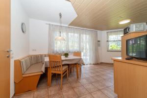 a dining room with a table and a tv at Haus Muntschnei in Sankt Gallenkirch