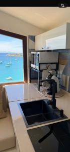 a kitchen with a sink and a view of the ocean at Amore di Mare in Cagliari