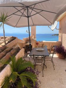 a patio with a table and chairs and an umbrella at Amore di Mare in Cagliari