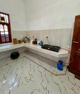 a kitchen with a counter with a stove on the floor at ThePopos in Arugam Bay