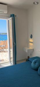 a bedroom with a blue bed and a view of the ocean at Amore di Mare in Cagliari +42 photos