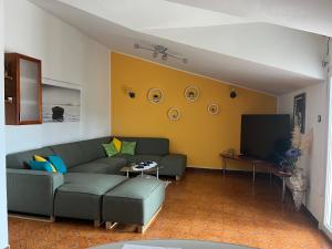 a living room with a couch and a tv at Kate's Home Tisno in Tisno
