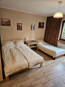 a hotel room with two beds and a table at Pokoje DARMAT in Stegna