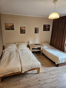 a bedroom with two beds and a table at Pokoje DARMAT in Stegna