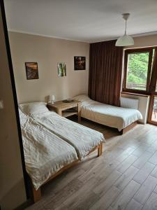 a hotel room with two beds and a window at Pokoje DARMAT in Stegna